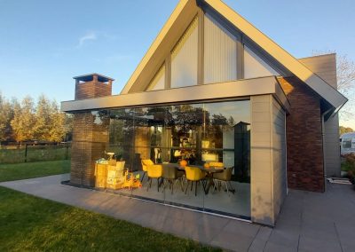 Veranda met strak plafond, glazen schuifdeuren, één dichte zijwand en Steellook schuifdeur 39 Keldonk